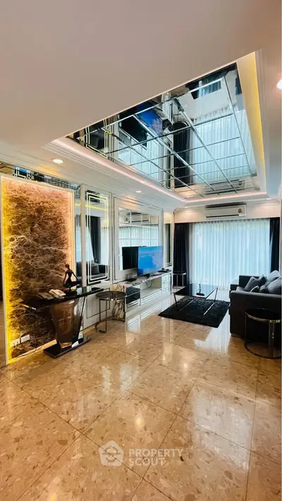 Luxurious living room with marble flooring and mirrored ceiling, featuring modern decor and ample natural light.