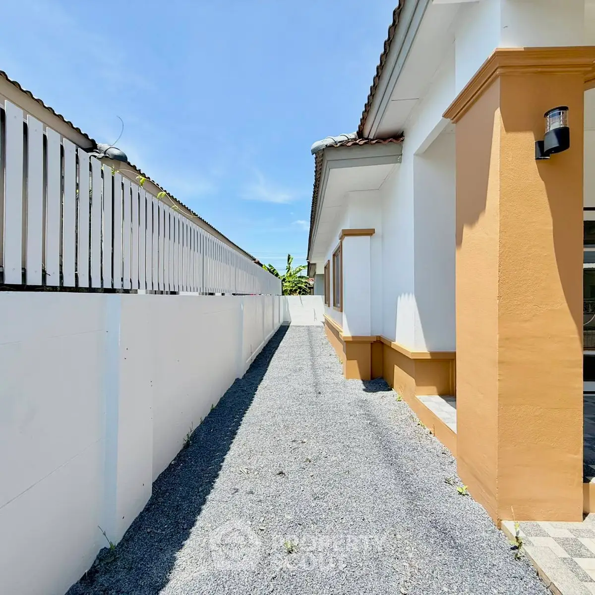 Charming exterior view of a modern house with a gravel pathway and bright facade.