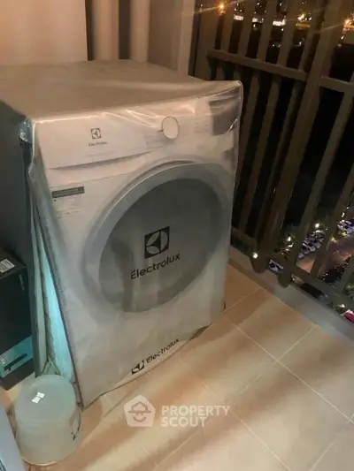 Modern Electrolux washing machine on a balcony with city view, perfect for urban living convenience.