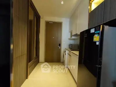 Modern kitchen with sleek appliances and washing machine in compact layout.