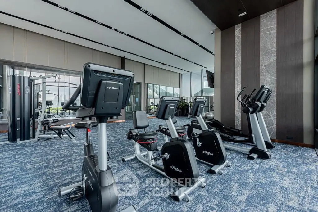Spacious modern gym with state-of-the-art fitness equipment and panoramic windows.