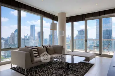 Luxurious living room with panoramic city views and modern furnishings in high-rise apartment.
