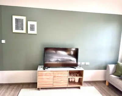 Modern living room with stylish TV stand and green accent wall