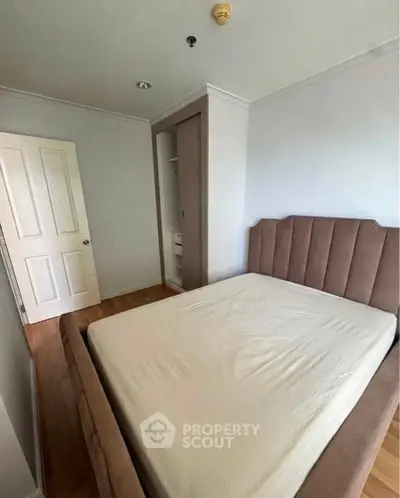 Cozy bedroom with plush bed and built-in closet in modern apartment