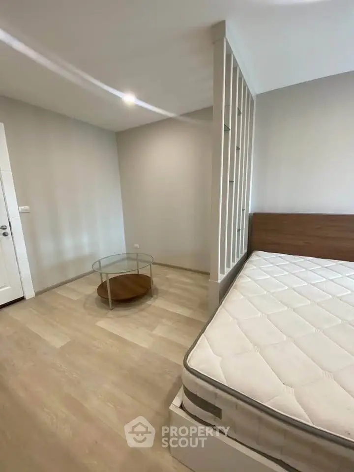 Spacious bedroom with modern design and natural light, featuring a comfortable mattress and stylish decor.
