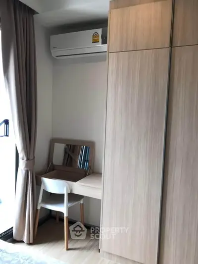 Modern bedroom corner with wardrobe, desk, and air conditioning unit.