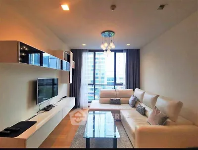 Modern living room with sleek furniture and large window offering city view