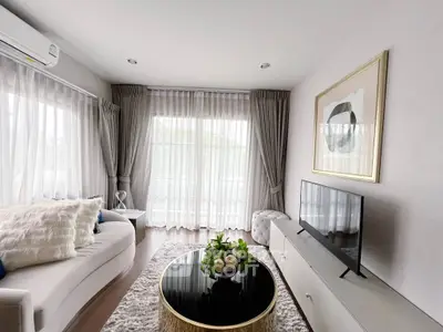 Elegant living room with modern decor, large windows, and stylish furniture for a cozy ambiance.