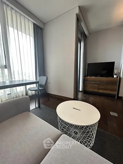 Modern living room with stylish furniture and large windows offering natural light.