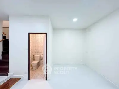 Minimalist interior with small bathroom and staircase, ideal for compact living spaces.