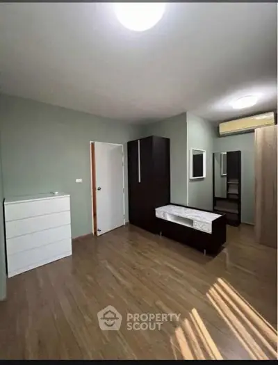 Spacious bedroom with modern furniture and wooden flooring