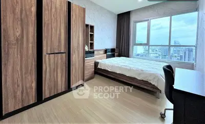 Modern bedroom with city view, featuring sleek wooden furniture and large window for natural light.