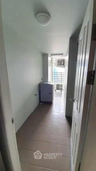 Compact laundry area with washing machine and balcony view in modern apartment.
