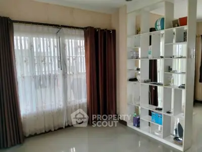 Spacious living room with elegant shelving and large windows for natural light.