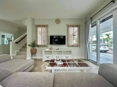 Spacious modern living room with stylish decor and large windows overlooking driveway