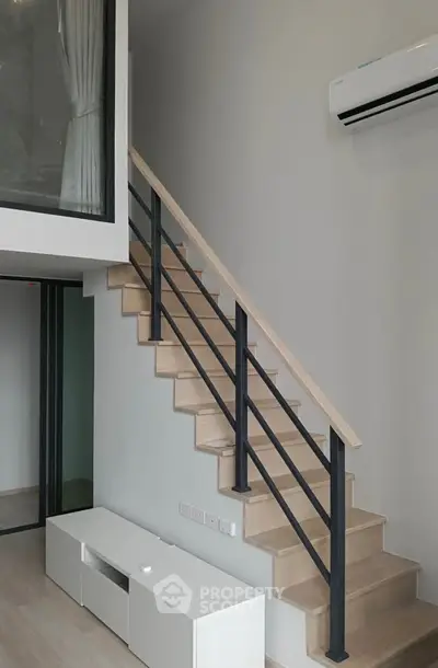 Modern duplex interior with sleek staircase and air conditioning unit
