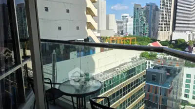 Stunning city view from a modern balcony with glass railing and outdoor seating.
