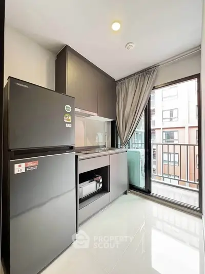 Modern kitchen with sleek appliances and balcony view in a stylish apartment.