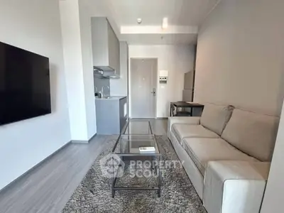 Modern living room with sleek furniture and open kitchen layout in a stylish apartment.