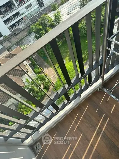 Charming balcony view with lush greenery and modern railing, perfect for relaxation and enjoying the outdoors.