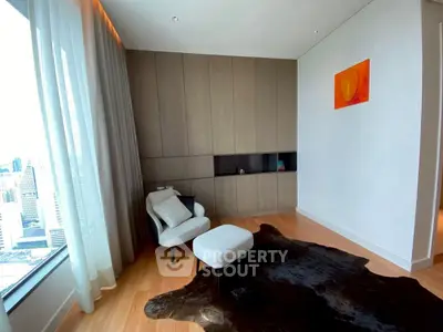 Modern living room with city view, featuring stylish armchair and contemporary decor.