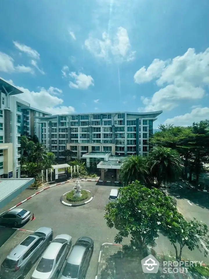 Stunning view of modern residential building with lush greenery and ample parking space.