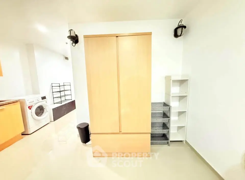 Spacious laundry area with modern washing machine and ample storage space