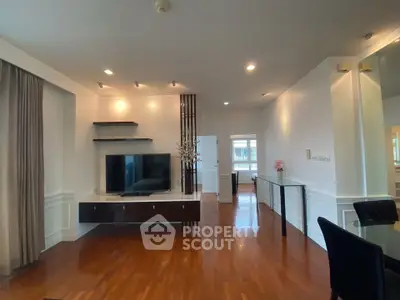 Spacious living room with modern decor and hardwood floors in a stylish apartment.
