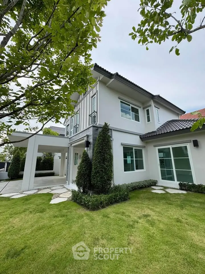Stunning modern two-story house with lush green lawn and elegant exterior design.