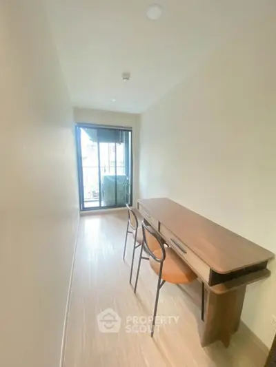 Modern study room with sleek desk and chairs, bright natural light from balcony.