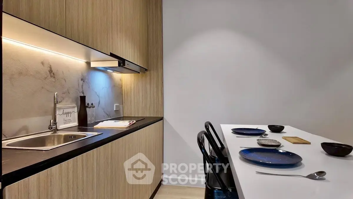 Modern kitchen with sleek cabinetry and dining area in stylish apartment
