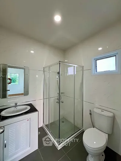 Modern bathroom with glass shower enclosure and sleek fixtures