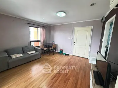 Spacious living room with wooden flooring and modern furnishings in a cozy apartment.