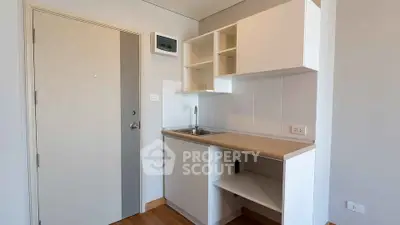 Compact modern kitchen with sleek cabinetry and wooden countertop