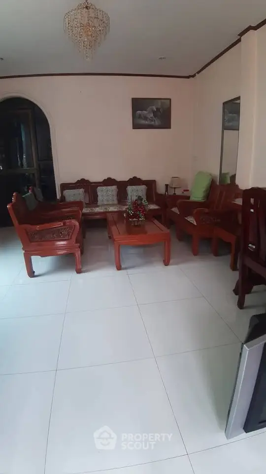 Spacious living room with elegant wooden furniture and chandelier