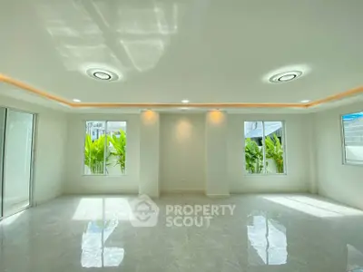 Spacious modern living room with large windows and elegant lighting