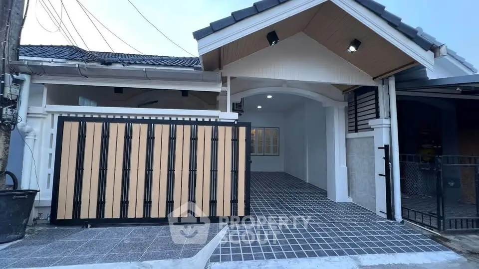 Charming single-story home with modern gate and tiled driveway, perfect for comfortable living.