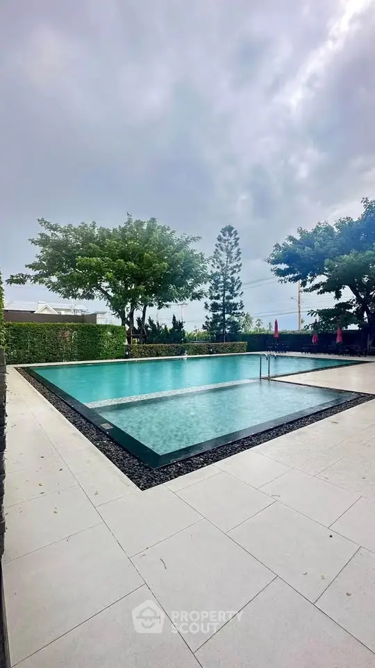 Luxurious outdoor pool area with lush greenery and serene ambiance.