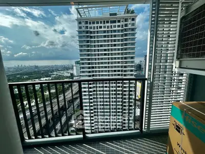 Stunning high-rise balcony view with cityscape and ocean horizon, perfect for urban living.