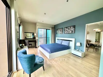 Spacious modern bedroom with elegant decor and city view balcony access.