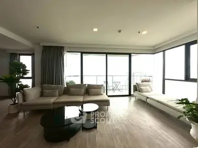 Spacious modern living room with large windows and balcony access.