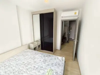 Modern bedroom with sleek wardrobe and air conditioning in a minimalist apartment.