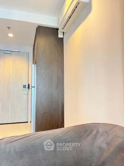 Modern apartment interior with air conditioning and sleek wooden cabinetry.
