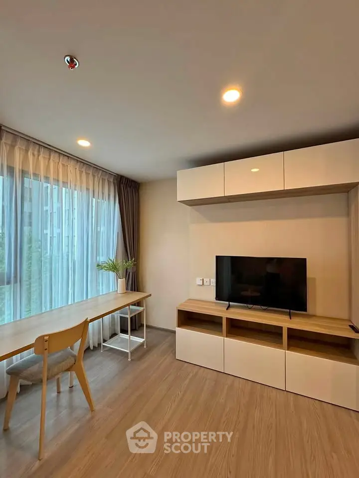 Modern living room with stylish furniture and large window offering natural light