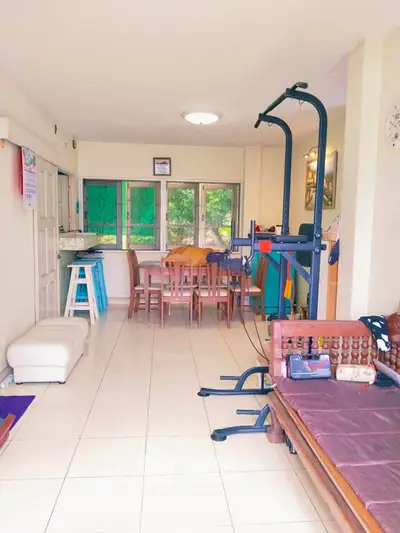 Spacious living room with dining area and exercise equipment, featuring bright natural light and modern decor.