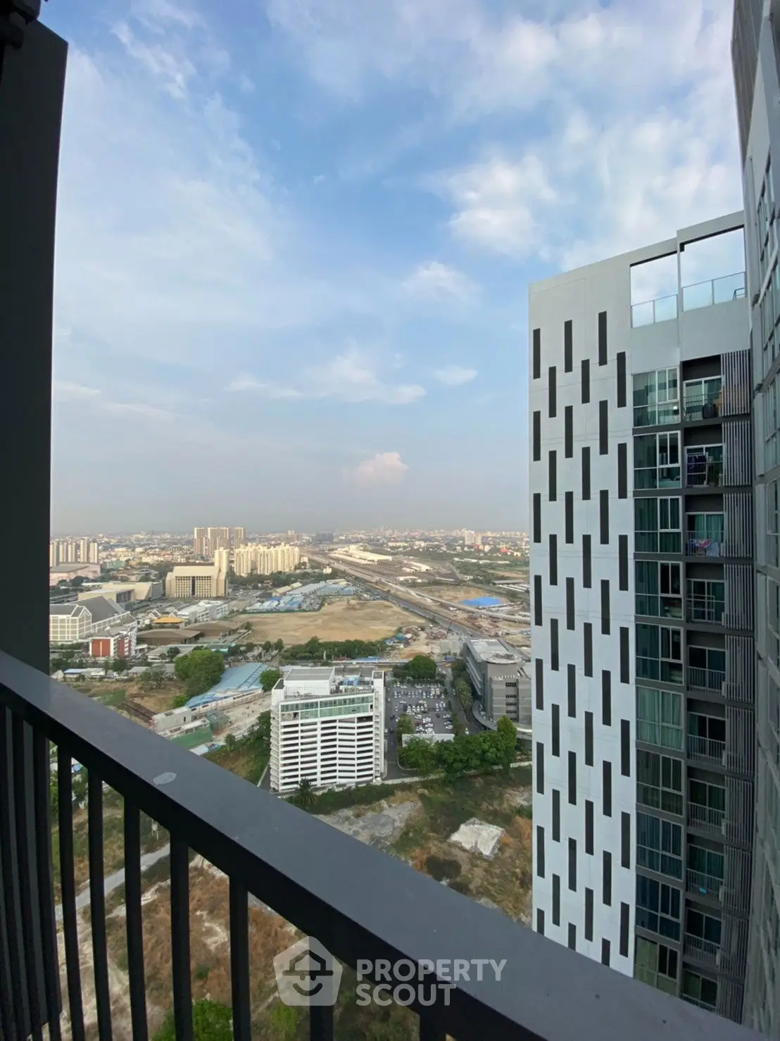 Stunning high-rise balcony view overlooking cityscape and modern architecture.