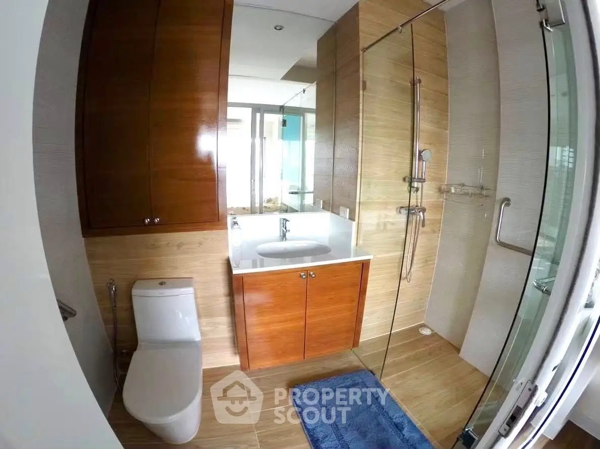 Modern bathroom with glass shower and wooden cabinetry