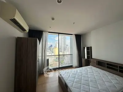 Spacious bedroom with city view and large window in modern apartment