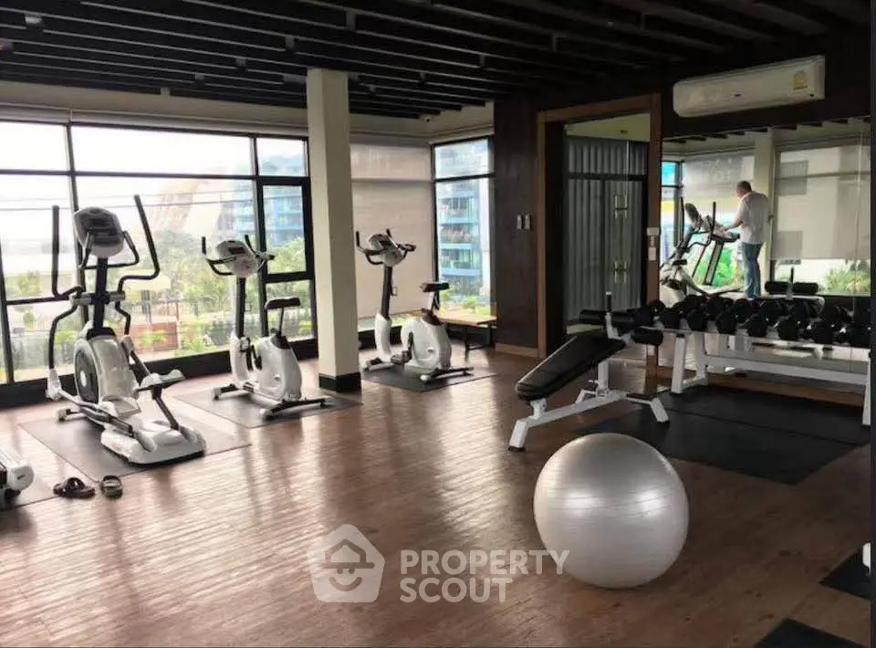 Modern gym with exercise equipment and large windows offering a scenic view.