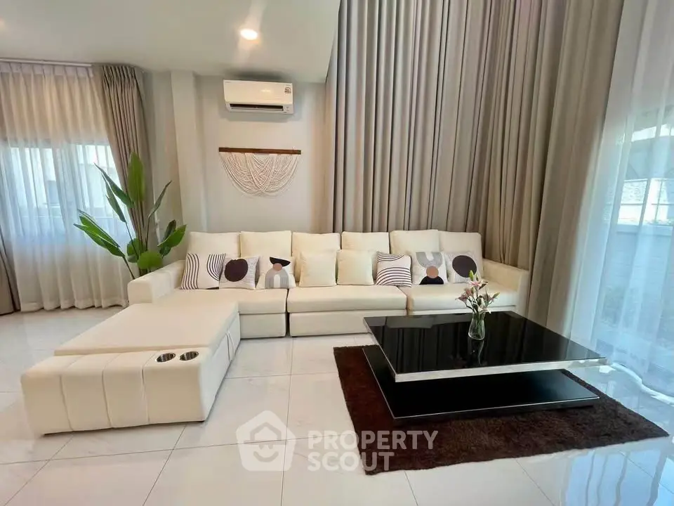 Luxurious living room with elegant decor and modern furniture, featuring a spacious white sofa and stylish coffee table.
